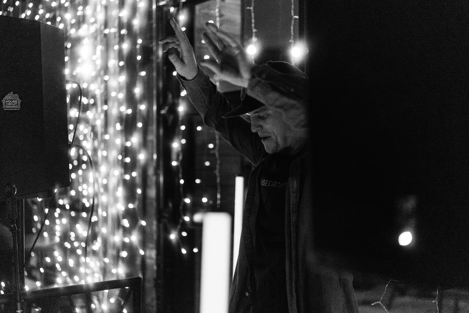 Hands up under the string lights at a House Circuit night